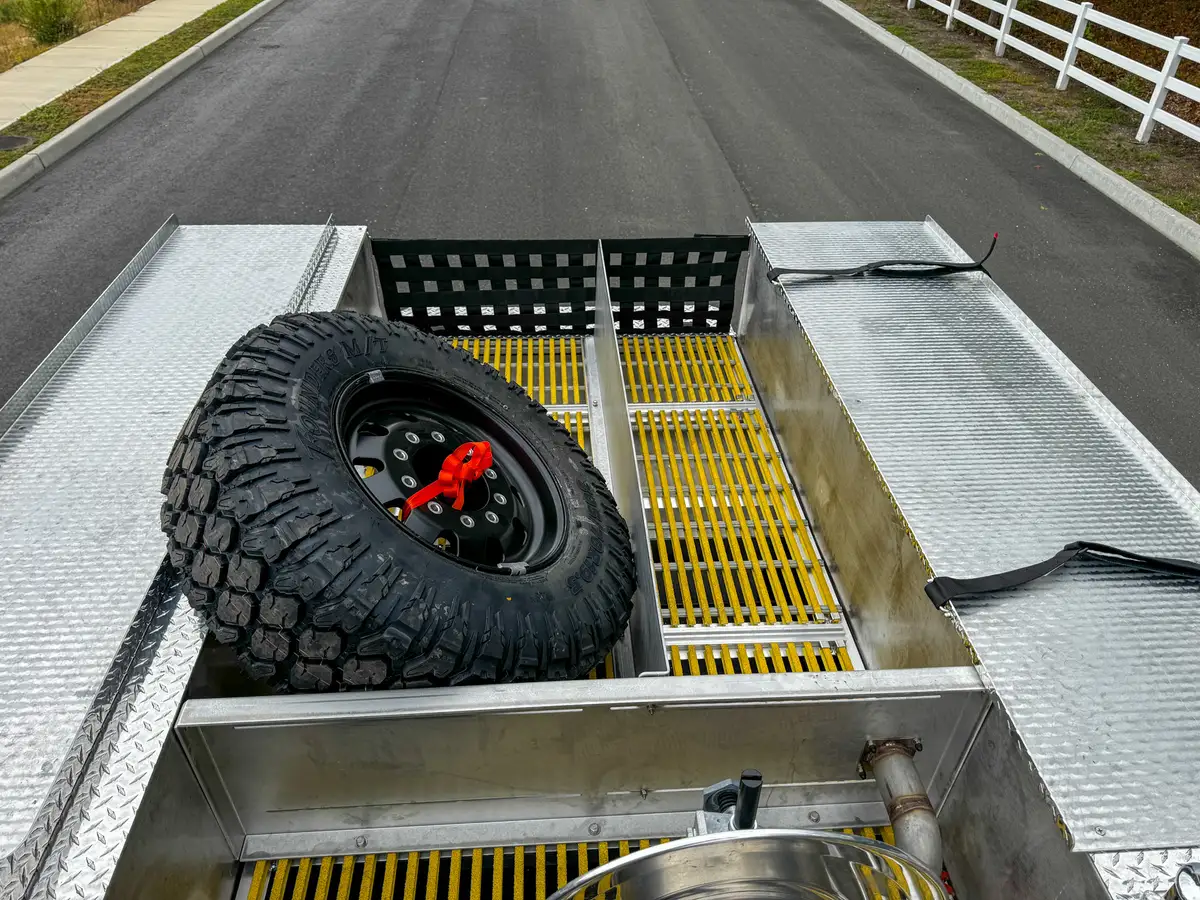 Top deck view showing spare tire bay and adjacent open grating section.